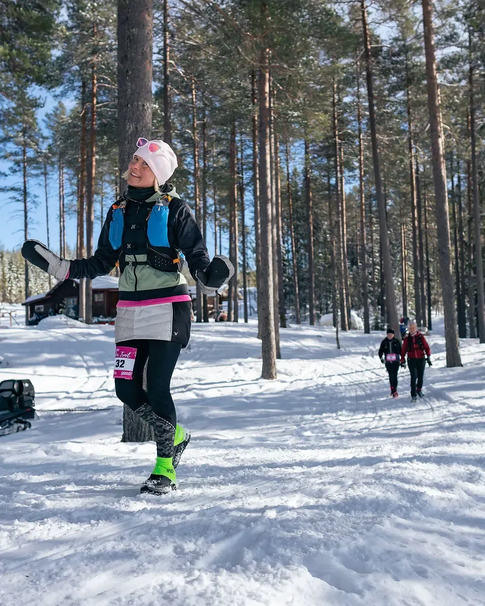 Löpare i Älvdalens vintertrail.  Snöig skog, bra stämning.