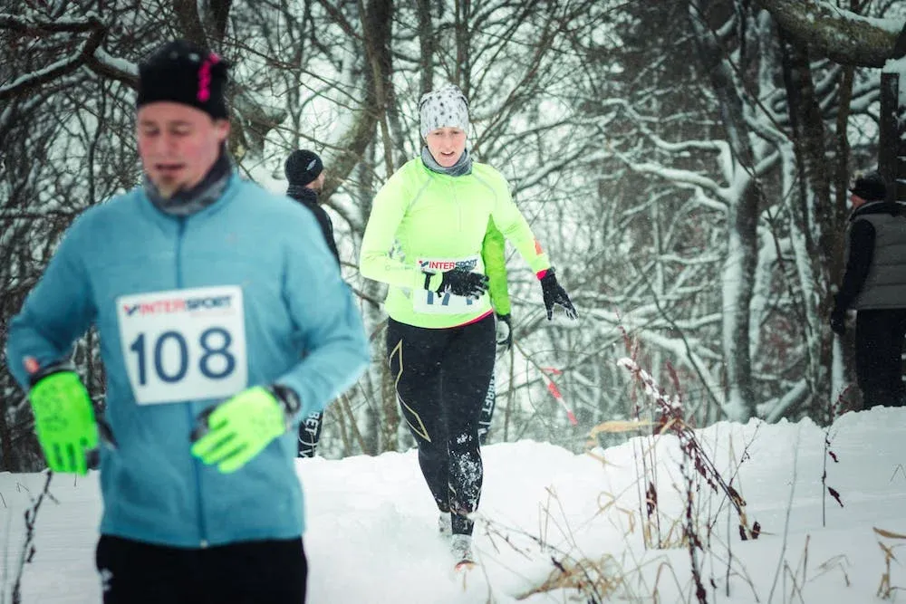 Löpare i snöig skog under Billingen Xtrail.