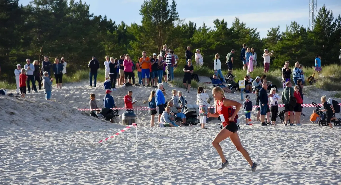 Löpare i Böda Beachrun. Sandstrand, publik.