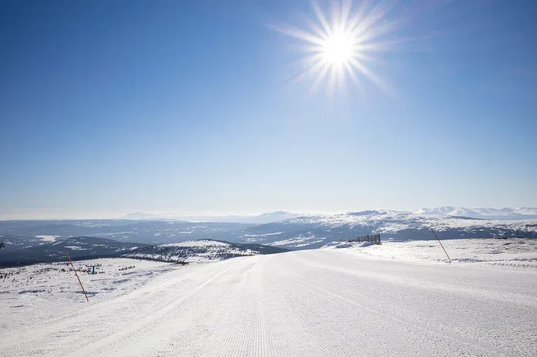 En snöig stig med vackra fjäll i bakgrunden.