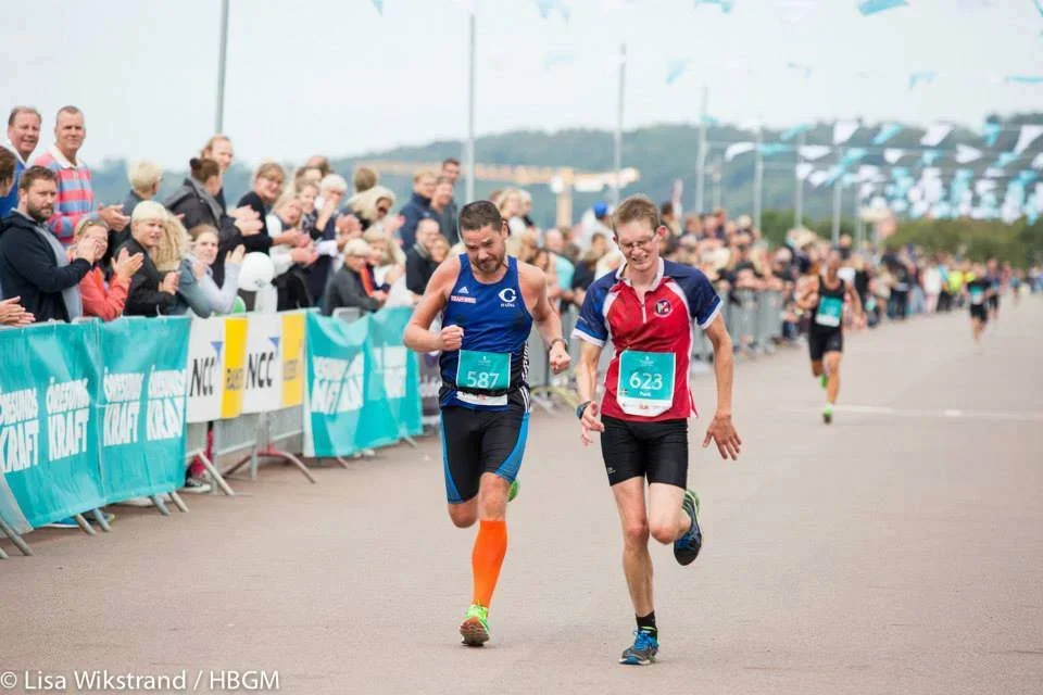 Helsingborg Marathon löpare spurta mot mållinjen, publik jublar.