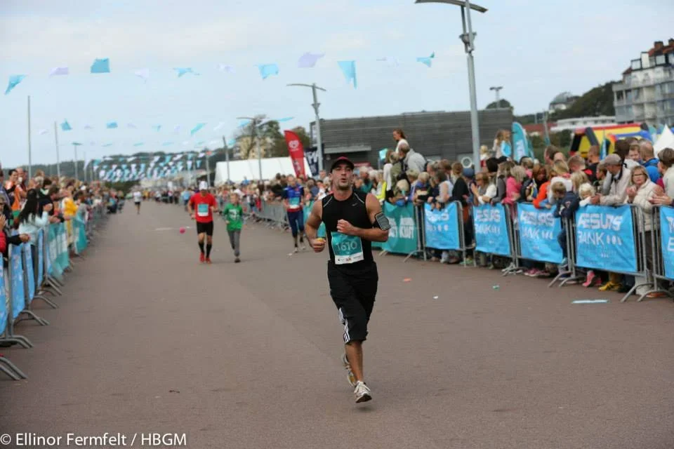 Helsingborg Marathon: Löpare springer förbi åskådare längs banan.