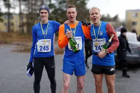 Tre löpare firar med medaljer och champagne efter ett lopp.