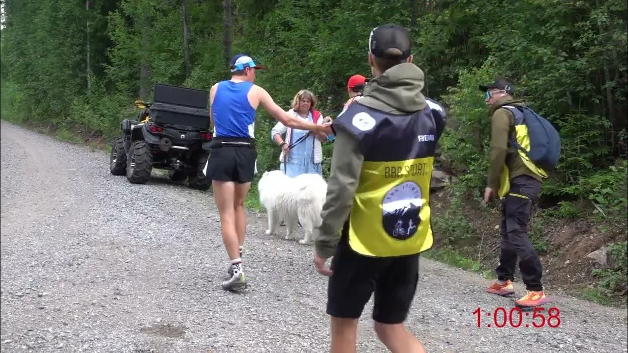 Silverleden Ultra: Löpare vilar vid en väg. Hundar och funktionärer syns.