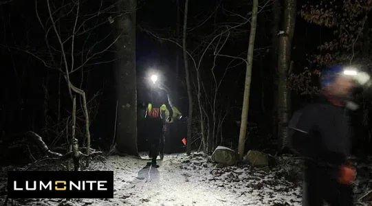 Två löpare med pannlampor i en mörk skog under nattloppet SpriT Frontyard - Dalby by Night.