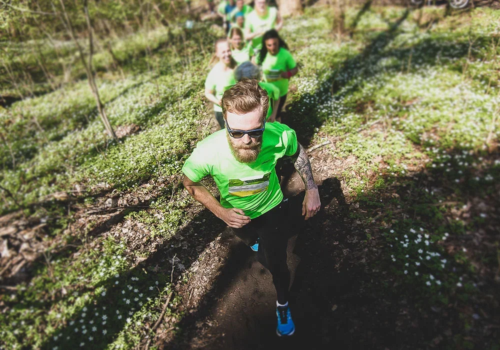 Löpare i grön t-shirt på en naturstig. Sthlm Trail Run.