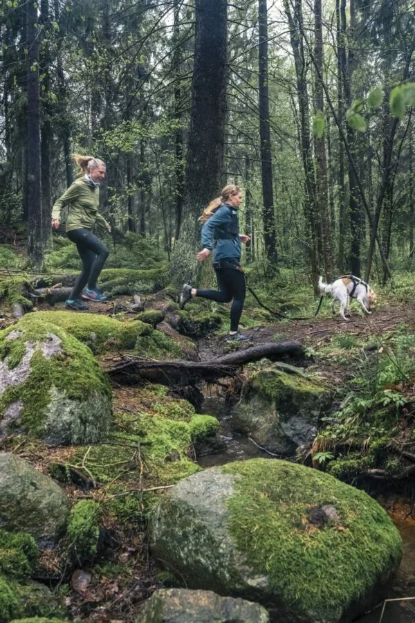 Två kvinnor springer i en skog under Sthlm Trail Run.