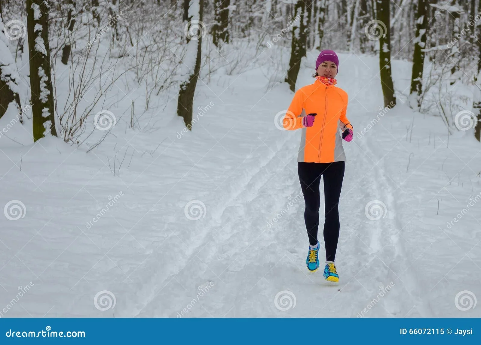 Kvinna springer i snöig skog. Perfekt för Vinterspringet!