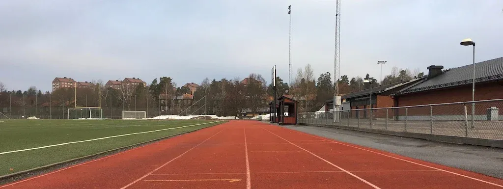 En löparbana med en skogslinje i bakgrunden.