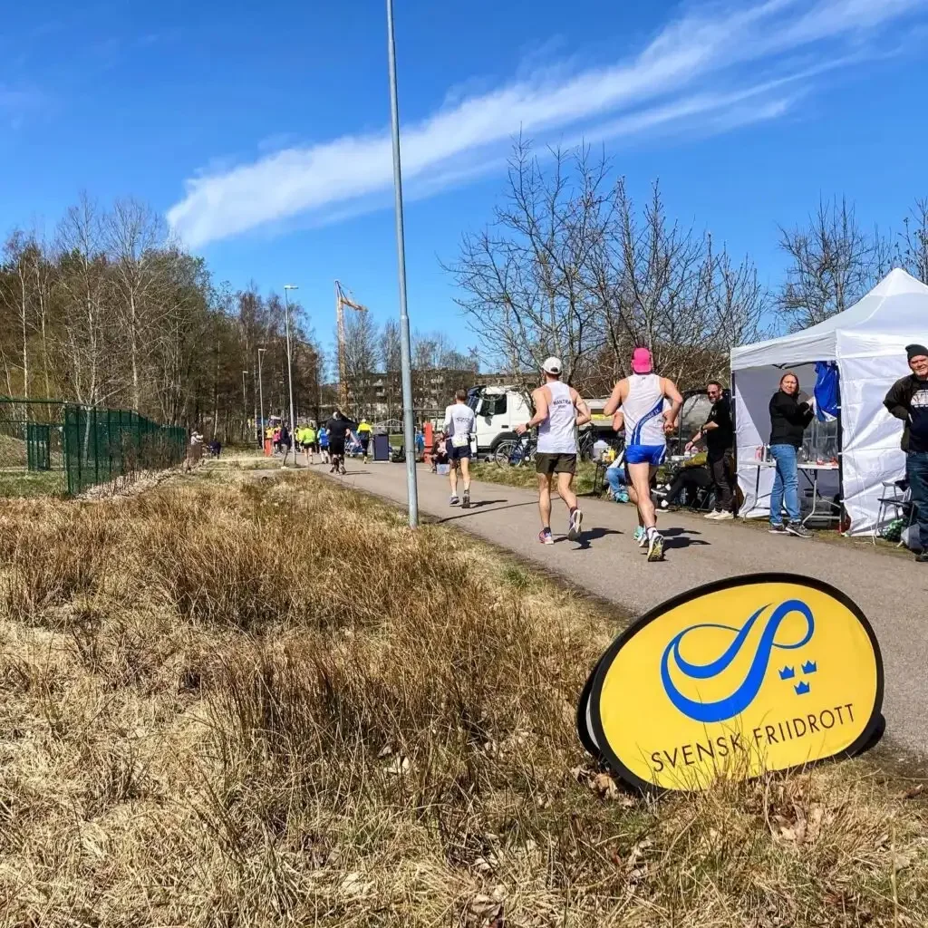 Löpare i ultramaraton med Svensk Friidrott-skylt.